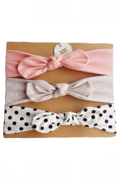 Stretchy grow-with-me set of three coordinating infant headbands with center bow, Gray and white chevron, white with black polkadots, solid pink.