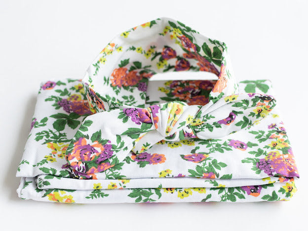 Floral jersey knit swaddle and matching headband. Stretchy jersey knit + cotton blend makes this the perfect swaddle for baby.