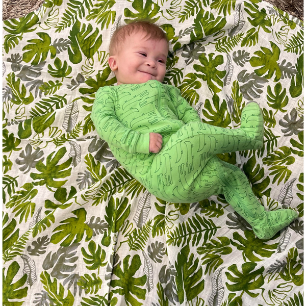 Baby Jace playing on his forest muslin swaddle. 